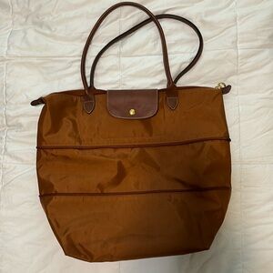 Longchamp Le Pliage cognac colored tote bag.